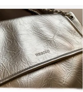 Detail shot of silver metallic pleated fabric texture and WEGOCO embossed logo on the bag