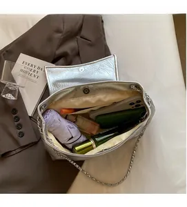 Interior view showing the large capacity and silver chain of this metallic shoulder bag