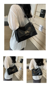 Detail view of black underarm tote bag with metal chain strap and subtle wrinkled texture