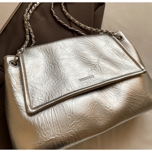 Macro shot of silver textured leather surface with metallic chain strap detail
