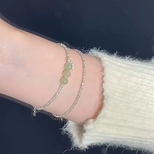 Gros plan d'un ensemble de bracelets en argent S925 avec perles de jade vert clair