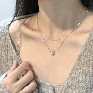 Close-up of double-layer S925 silver necklace with minimalist pearl pendant on a model