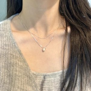 Close-up of a double-layer S925 silver necklace with a small pearl pendant on a model
