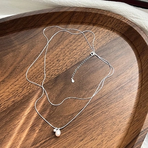 S925 silver double layer pearl pendant necklace with snake chain on a wooden tray