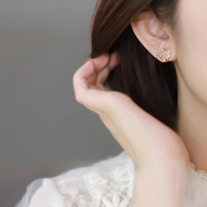 Elegant gold opal wreath clip earrings with colorful zircon worn by a model