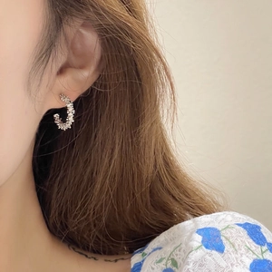 Irregular C-shaped silver earrings with crushed silver texture in minimalist metal style