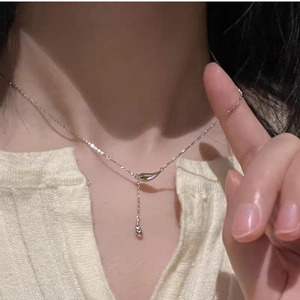 Silver teardrop tassel necklace on model neck showing minimalist sleek y-shaped chain
