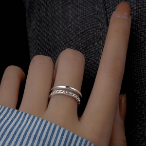 Close-up of a double-layered silver ring with smooth and twisted chain textures on hand