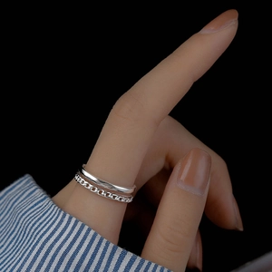 Detail of silver double-layer ring featuring a smooth band and textured chain design