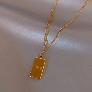 Golden rectangle bar necklace with GOLD engraving and mixed link chain on silk background