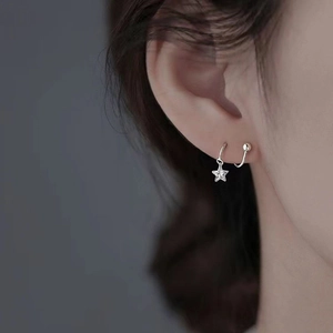 Macro shot of S925 sterling silver star earring with zircon inlay on model's ear