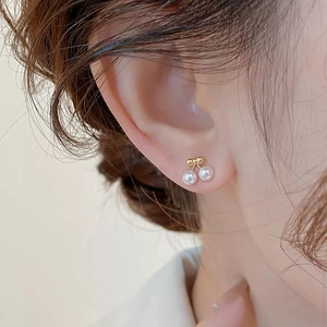 Exquisite cherry pearl stud earrings with gold bow design for a feminine, elegant look