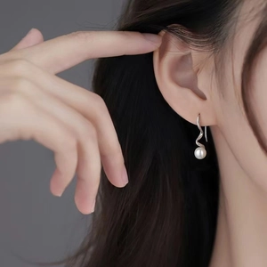 Minimalist S925 silver irregular spiral earrings with round white pearls on a model
