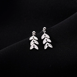 Boucles d'oreilles feuilles en argent S925 avec texture plume sur fond noir