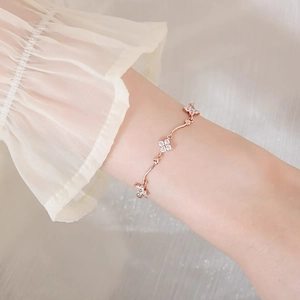 Elegant rose gold four-leaf clover bracelet with sparkling crystals on a female wrist