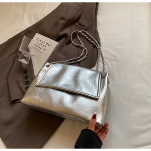 Detail of silver metallic wrinkled leather handbag with chain strap and logo