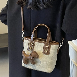 Retro canvas bucket bag in grey with brown leather handles and cute dog charm accessory