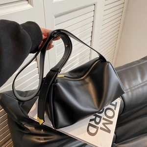 Minimalist black matte shoulder bag with wide strap and gold accents for daily commute