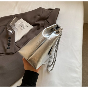Detailed macro view of silver metallic pleated shoulder bag with chic chain strap