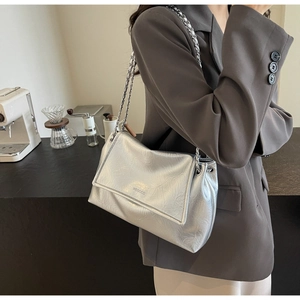 Close-up of metallic silver shoulder bag with wrinkled leather texture and chain strap