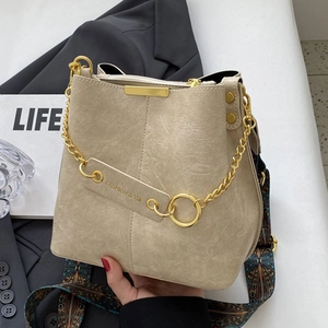 Schicke beige Eimertasche mit Litschi-Textur und Ethno-Gurt für einen modernen Look