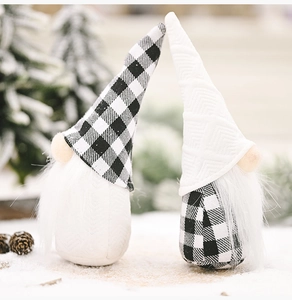 Close-up of black and white plaid Christmas gnomes with plush beards on a snow-like scene