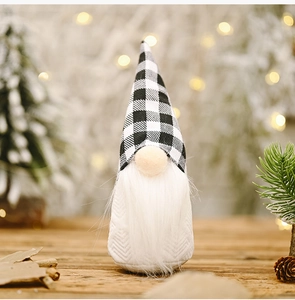 Detail of Christmas gnome with black and white plaid hat and long white beard on snow background