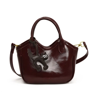Deep burgundy oil wax leather bucket bag with cute black cat charm and shoulder strap