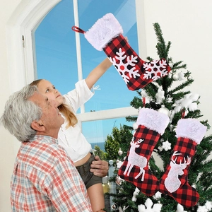 Chaussettes de Noël à carreaux rouges et noirs avec rennes décorant un sapin de Noël