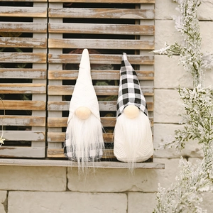Pair of Christmas gnomes with black and white plaid hats on stone countertop