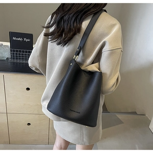 Close-up of black lychee grain leather bucket bag with FASHION & BAGS lettering detail