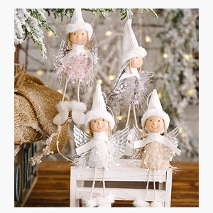 Detail of Christmas angel plush dolls with silver wings and knit hats in festive decor
