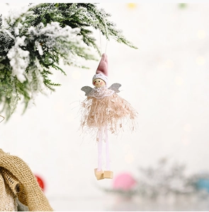 Macro detail of plush Christmas angel ornament with pink velvet hat and feather skirt