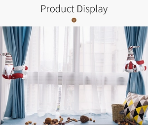 Detail of Christmas gnome curtain tiebacks with striped hats in a home window setting