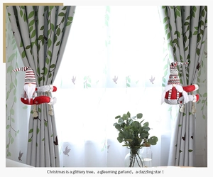 Detail of red and grey Christmas gnome curtain tiebacks hanging on window drapes