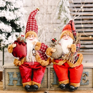 Set of two standing Santa Claus figurines with red plaid hats and holiday gift accessories