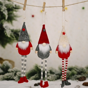 Three Christmas gnomes with striped legs and stars hanging on a rope with wooden clips