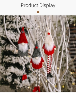 Three plush Christmas gnomes with long striped legs hanging on white festive branches