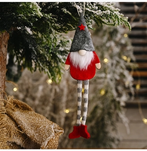 Close-up of Christmas gnome ornament with red star hat and striped legs on tree