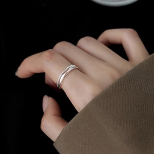 Macro shot of double-layered irregular twist ring with silver polished finish on finger
