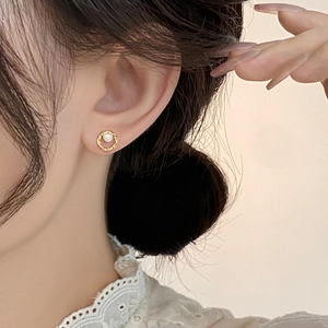Boucles d'oreilles perles rétro dorées portées par un mannequin au style élégant