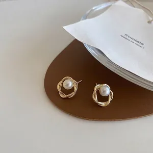 Boucles d'oreilles perles dorées torsadées élégantes sur support en cuir marron