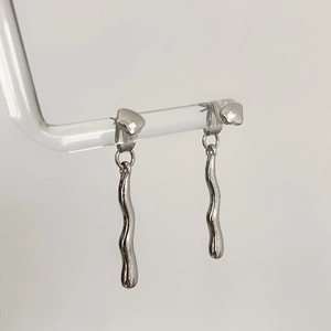 Macro detail of irregular geometric wavy drop earrings in silver liquid metal finish