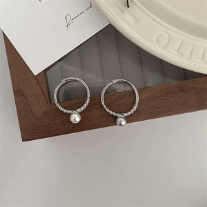 Close-up of adjustable silver twist rings with hanging white and grey pearls