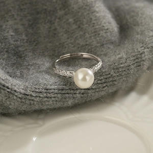 Exquisite pearl ring with wheat ear motif and zircon accents on a woven background
