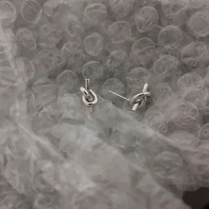 Polished 925 sterling silver knot stud earrings featuring a minimalist heart-shaped design