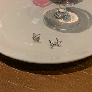 Sparkling crystal butterfly stud earrings displayed elegantly on a white ceramic plate
