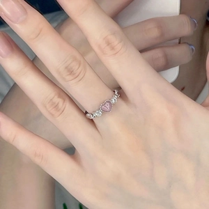 Elegant silver heart ring with pink cat eye stone and tiny diamonds on finger