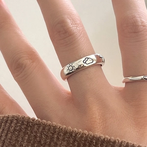 Minimalist silver weather-themed ring featuring engraved sun and cloud icons on a smooth band