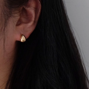 Boucles d'oreilles gouttes dorées minimalistes avec finition miroir sur l'oreille